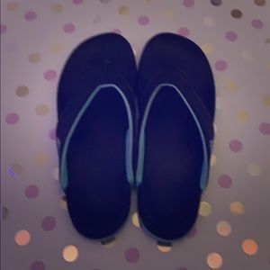 Black and teal Adidas flip flops